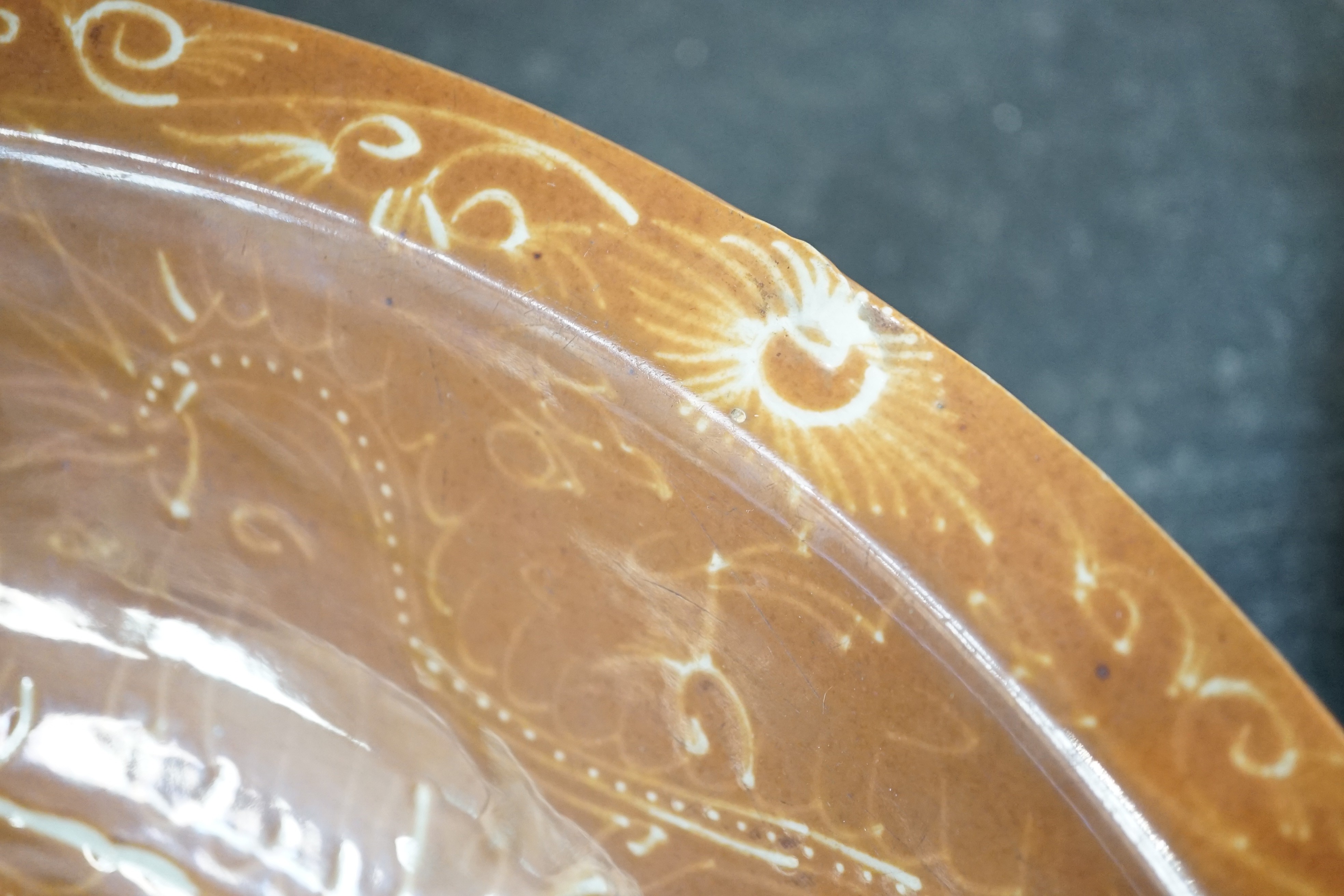 A Chinese Swatow slip-decorated brown ground dish, Zhangzhou kilns, early 17th century, 37cm diameter